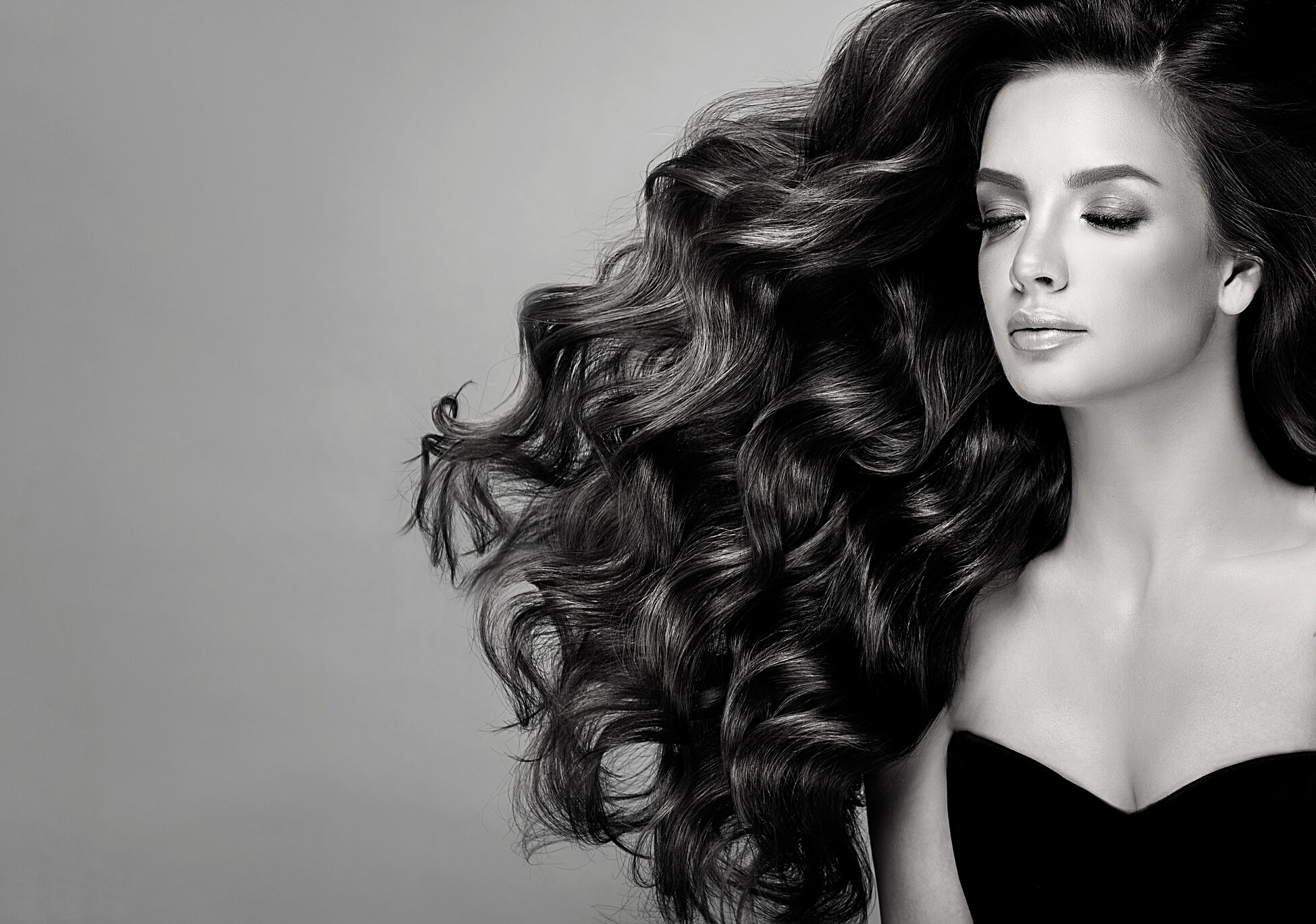 Young, brown haired beautiful model with long,  curly, well groomed hair. Excellent hair waves. Hairdressing art and hair care.